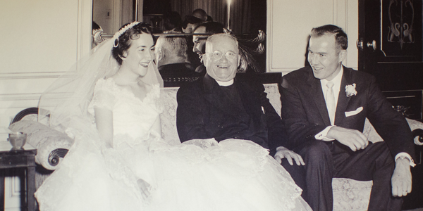 black and white photo of the groom, the bride, and the bride's father sitting together on a couch